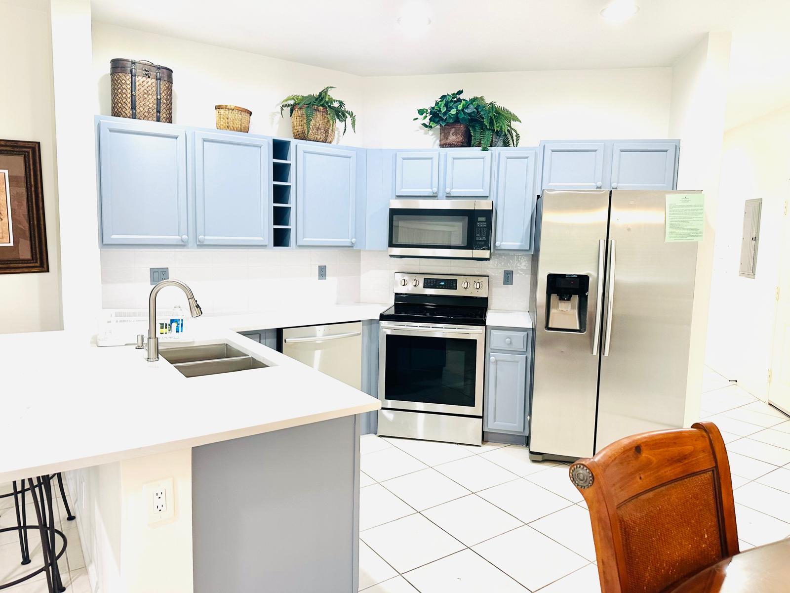 a kitchen with stainless steel appliances a refrigerator sink and microwave