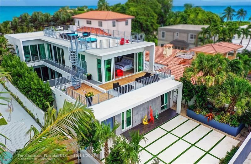 an aerial view of a house with balcony and trees