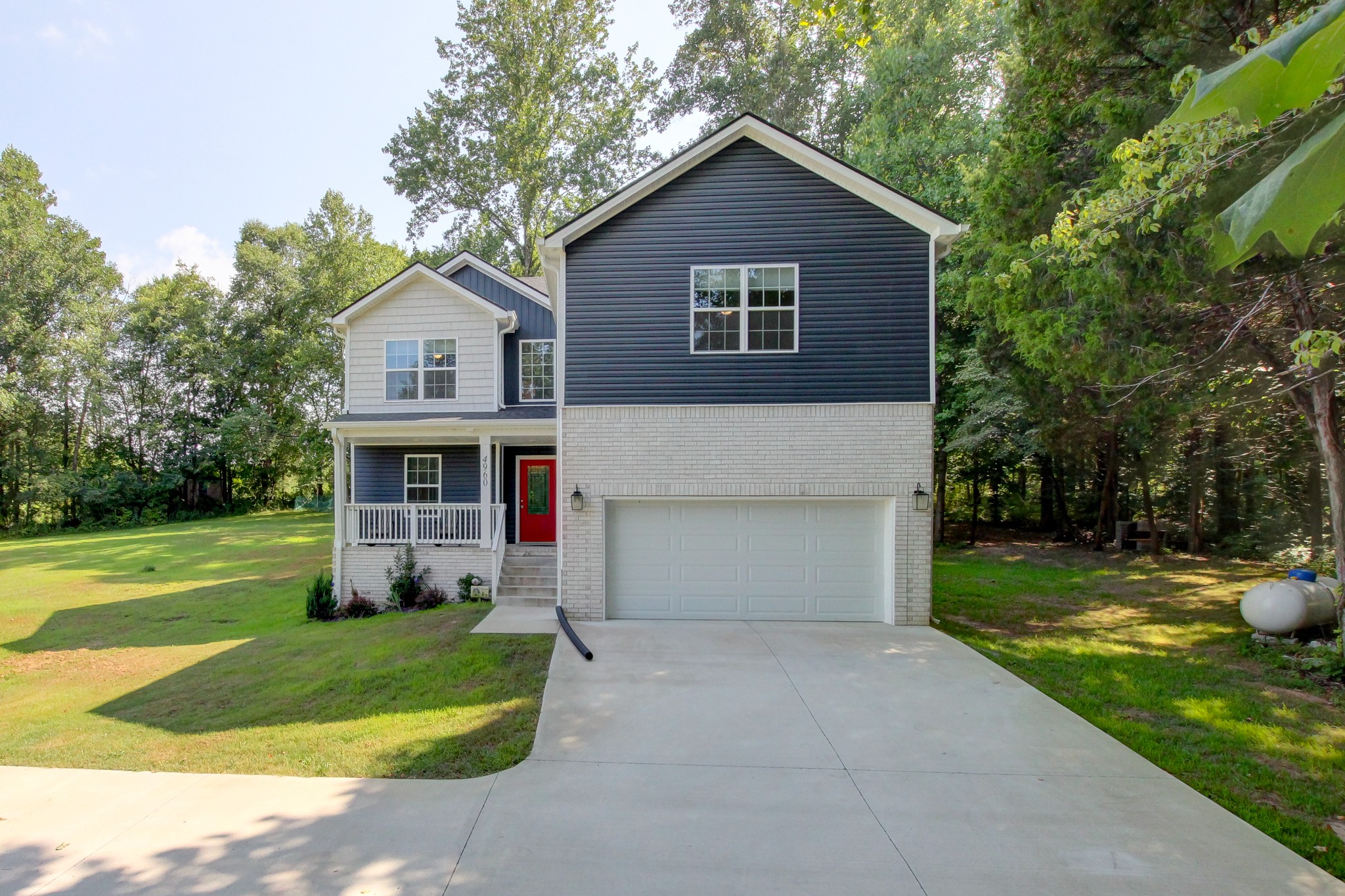 a front view of a house with a yard and trees