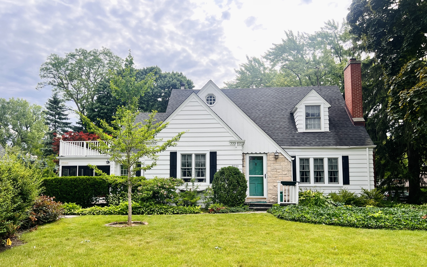 a front view of a house with a yard and trees