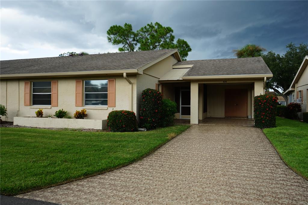 a front view of a house with a yard and potted plants