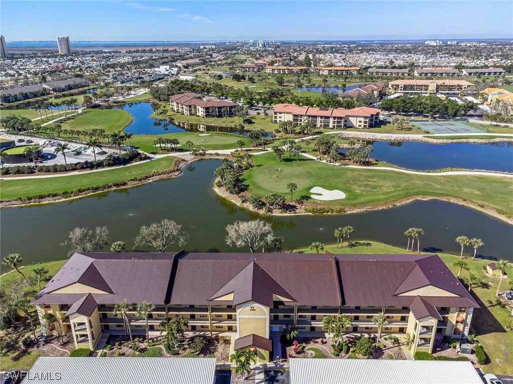 an aerial view of residential houses with outdoor space and lake view