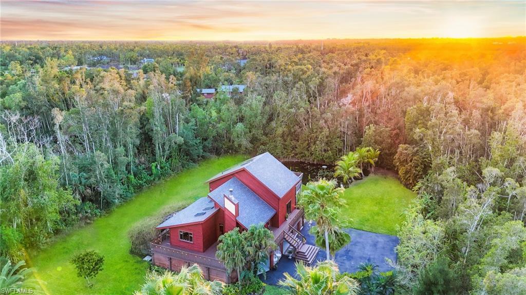 an aerial view of residential houses with outdoor space and trees