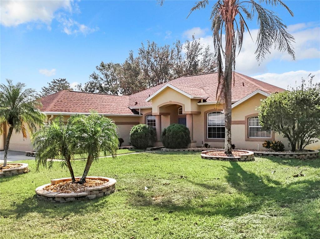 a front view of a house with a yard and swimming pool