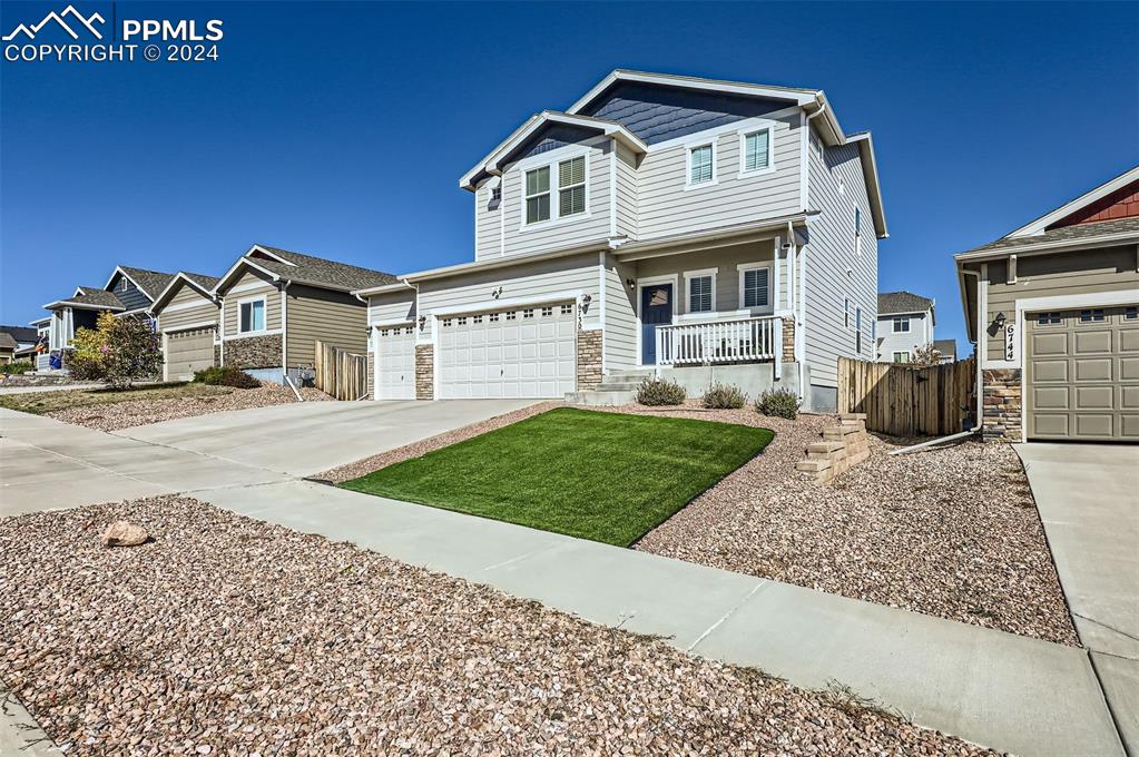 a front view of a house with a garden and yard