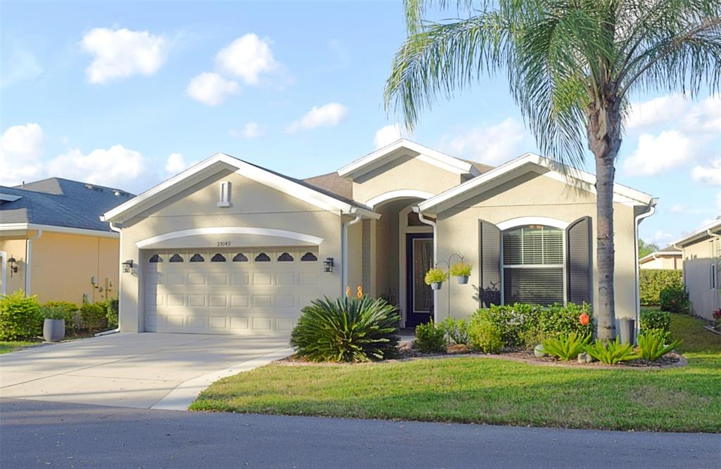 a front view of a house with a garden and palm trees