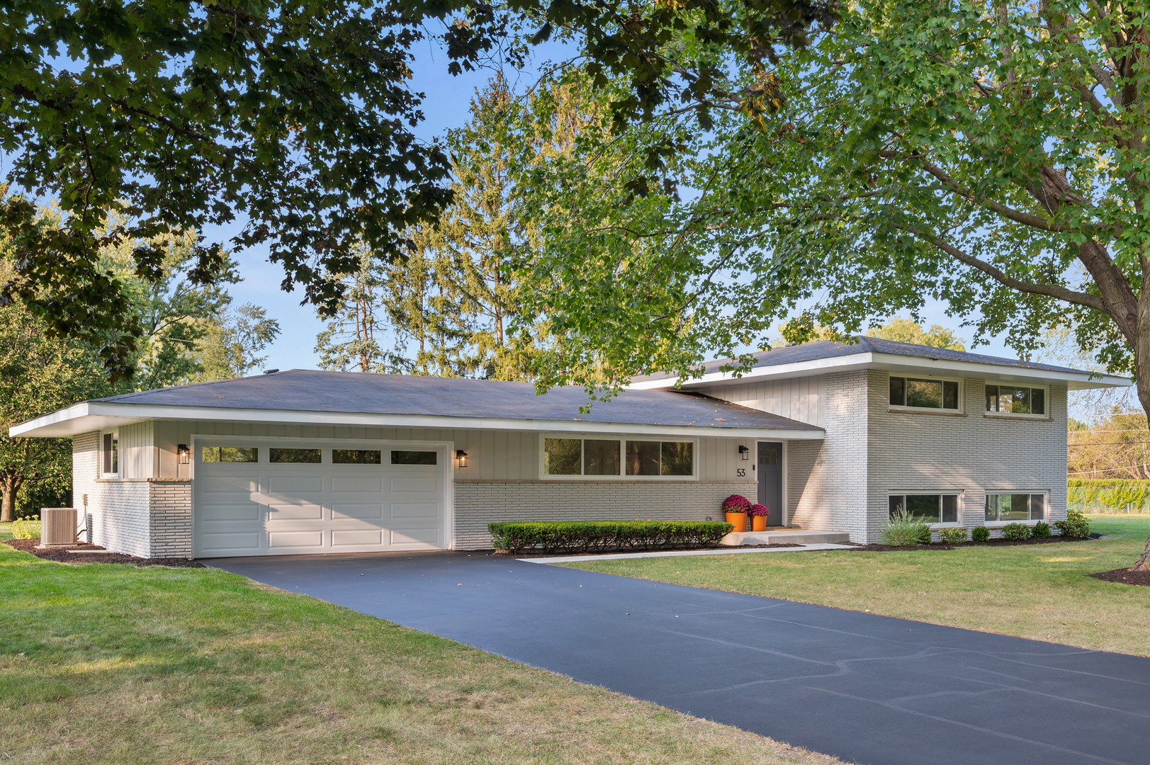 a view of a house with a yard and tree s