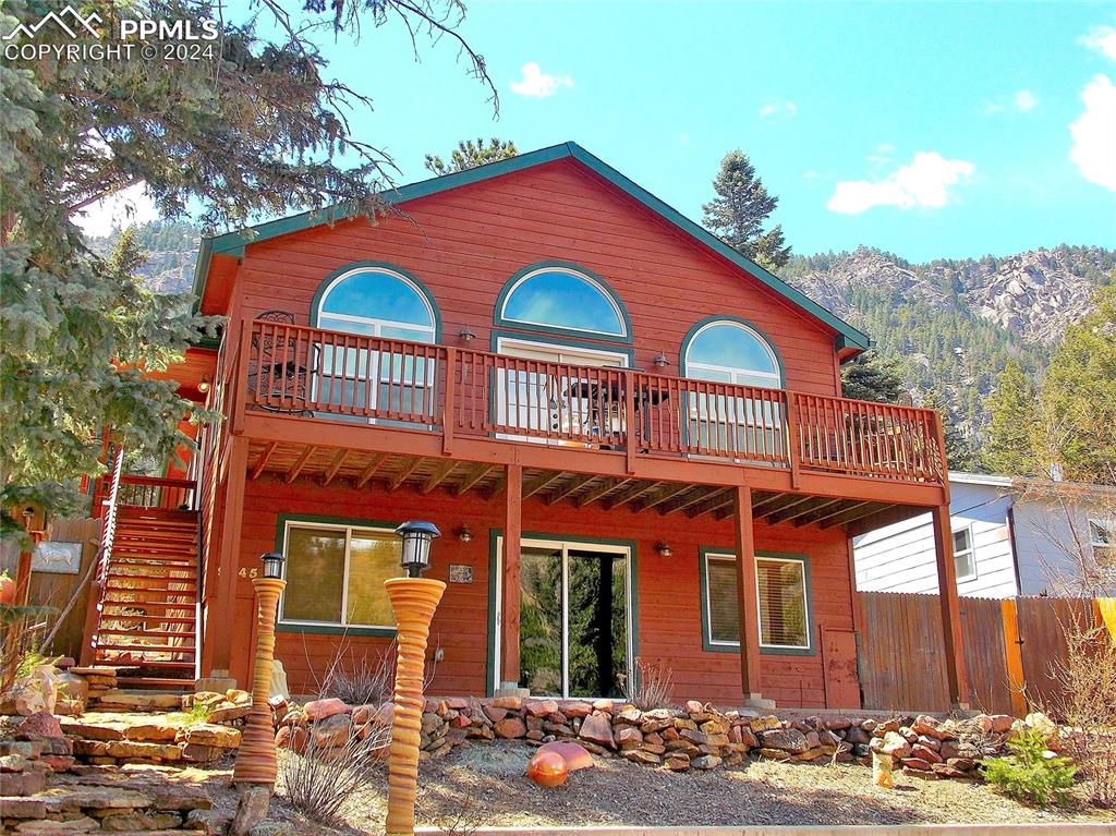 Front of house with deck & featuring a mountain view and a balcony