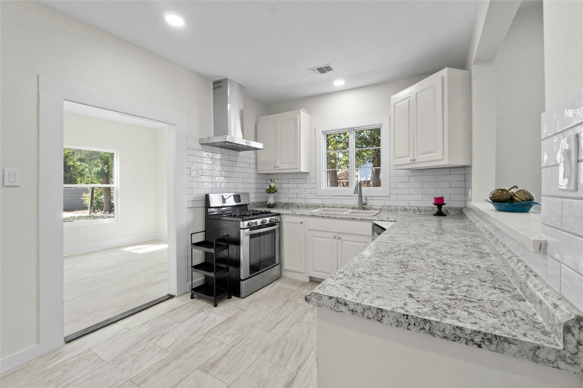 a kitchen with granite countertop a stove sink and cabinets