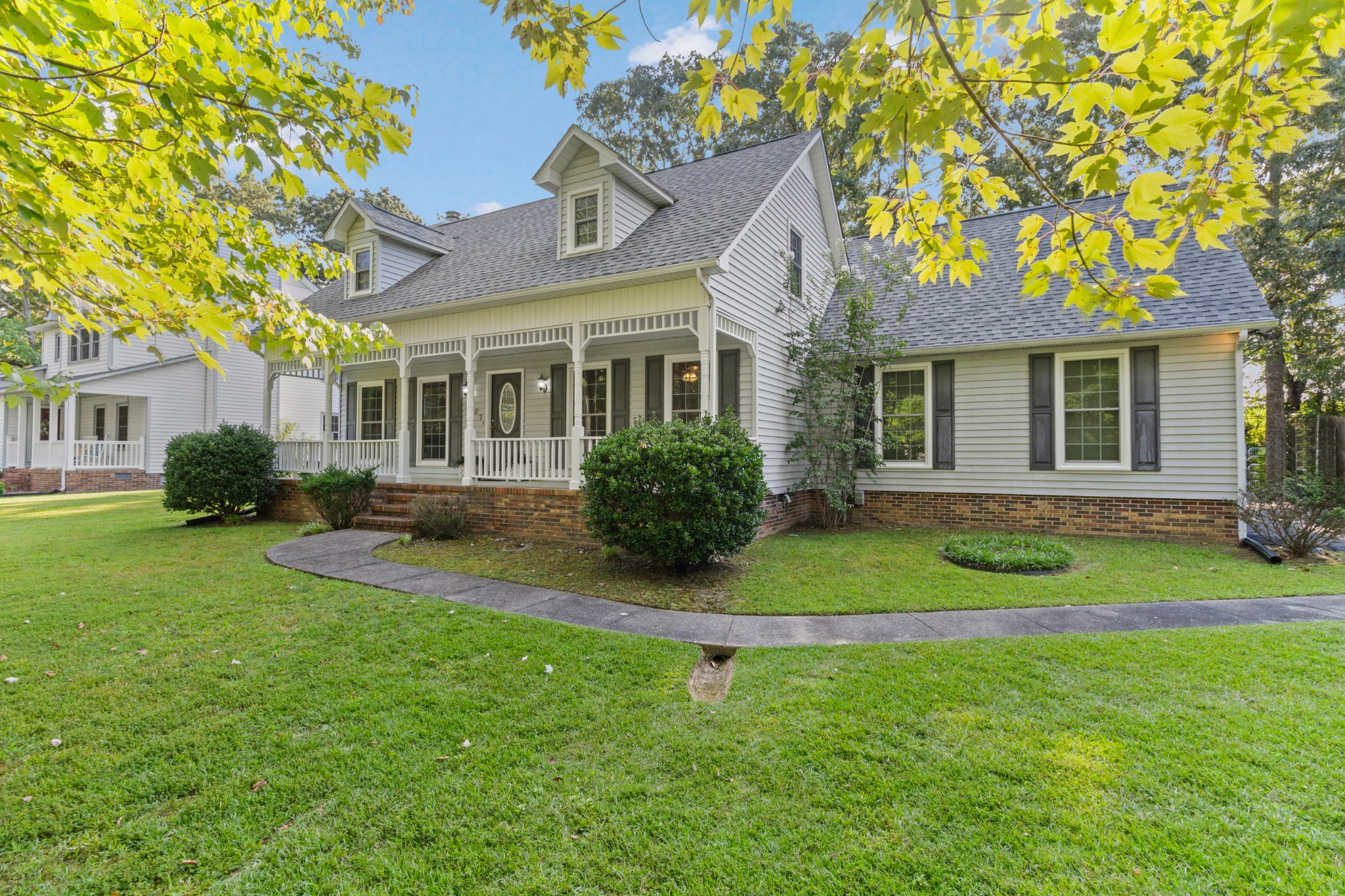 a front view of a house with a yard and trees