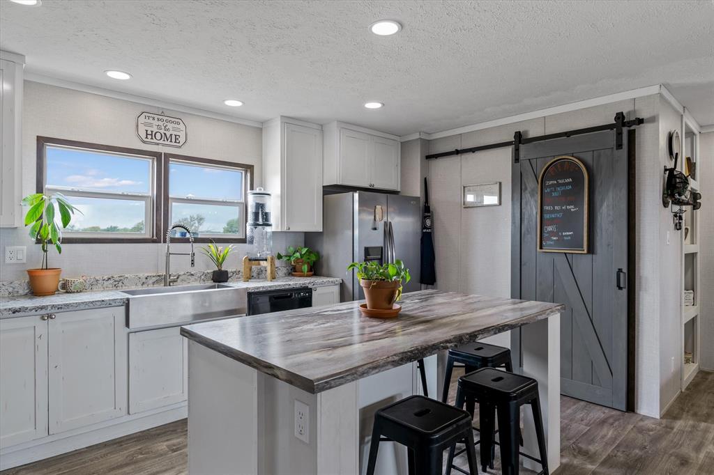 a kitchen with granite countertop a sink cabinets stainless steel appliances and dining table