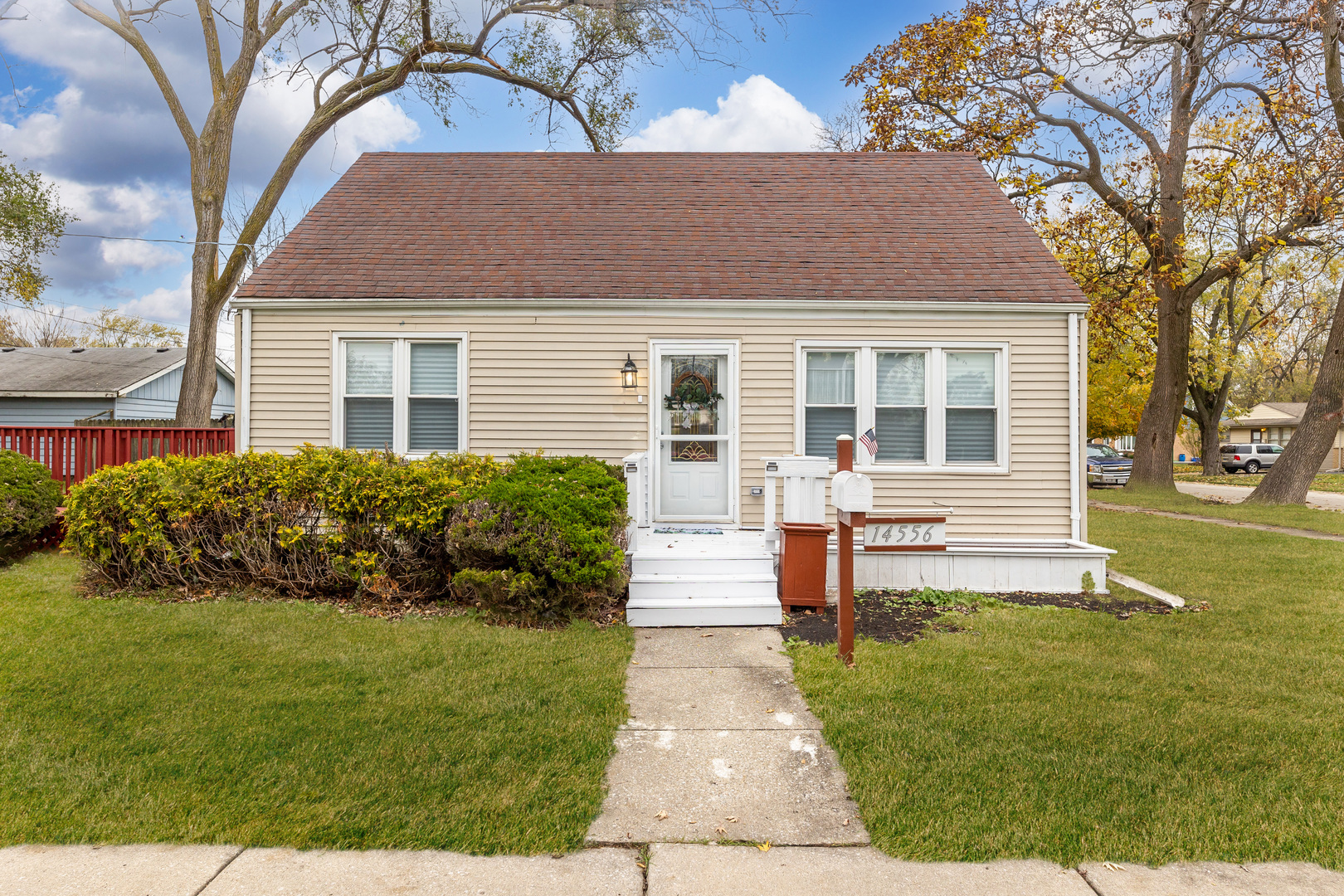 a front view of a house with a yard and trees