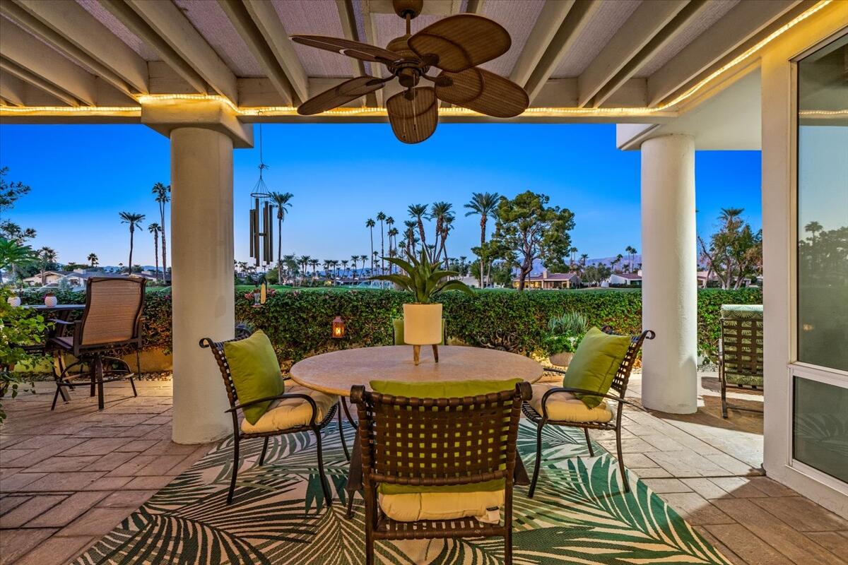 a view of a patio with a dining table and chairs with wooden floor