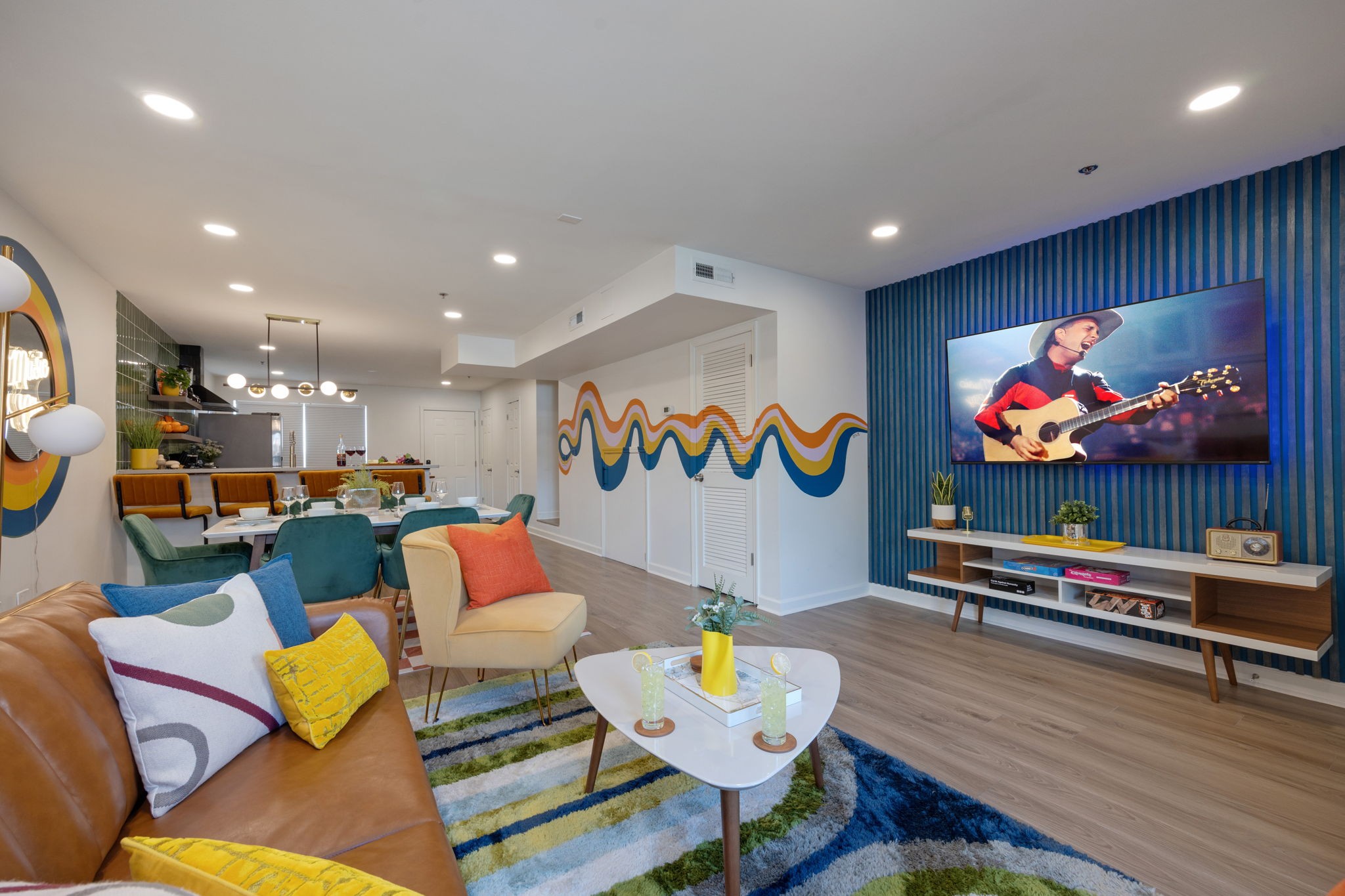 (1st Floor) Colorful open concept living room featuring multiple seating, smart TV, and designer decor.