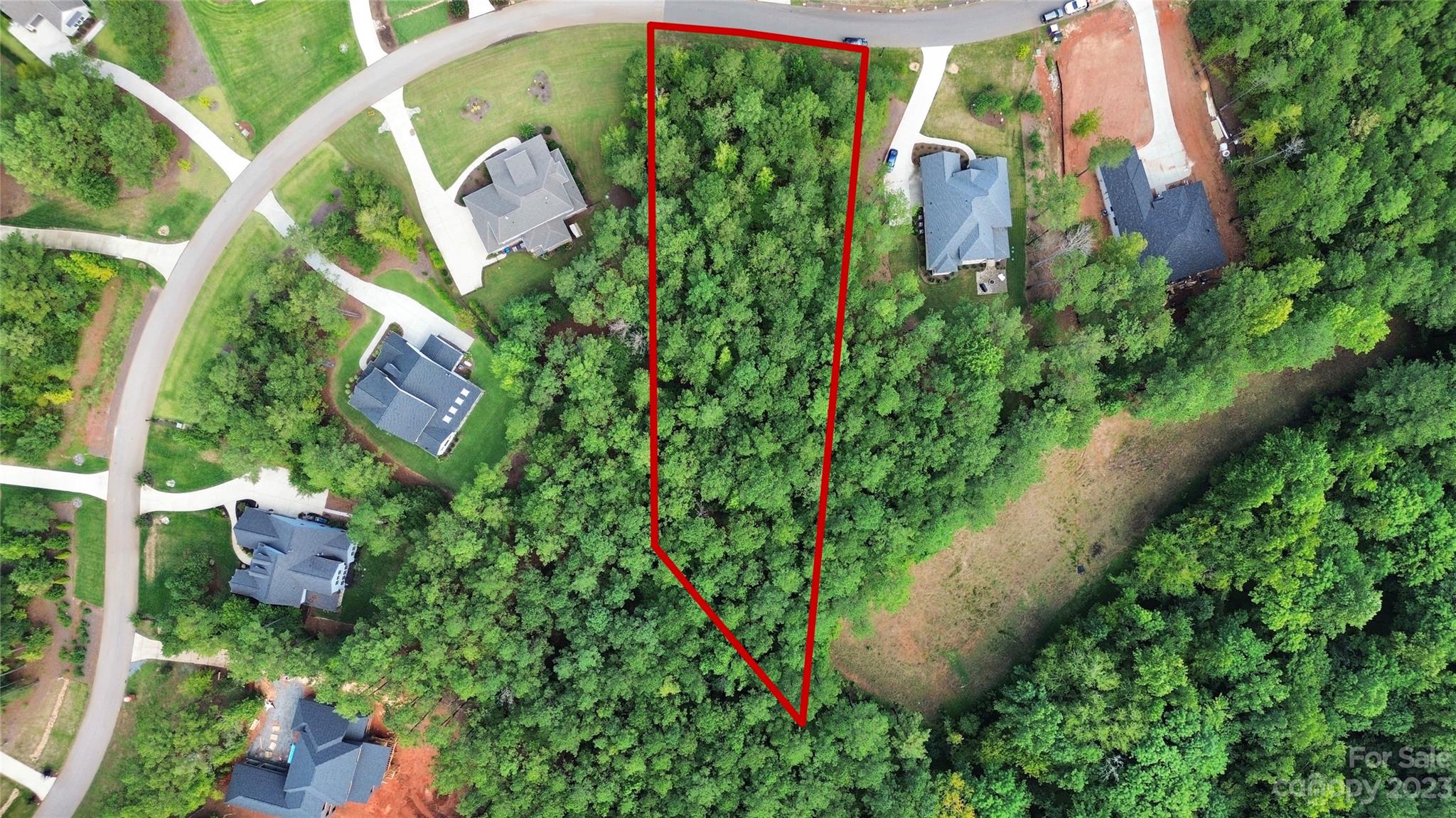 an aerial view of residential house with outdoor space and trees all around