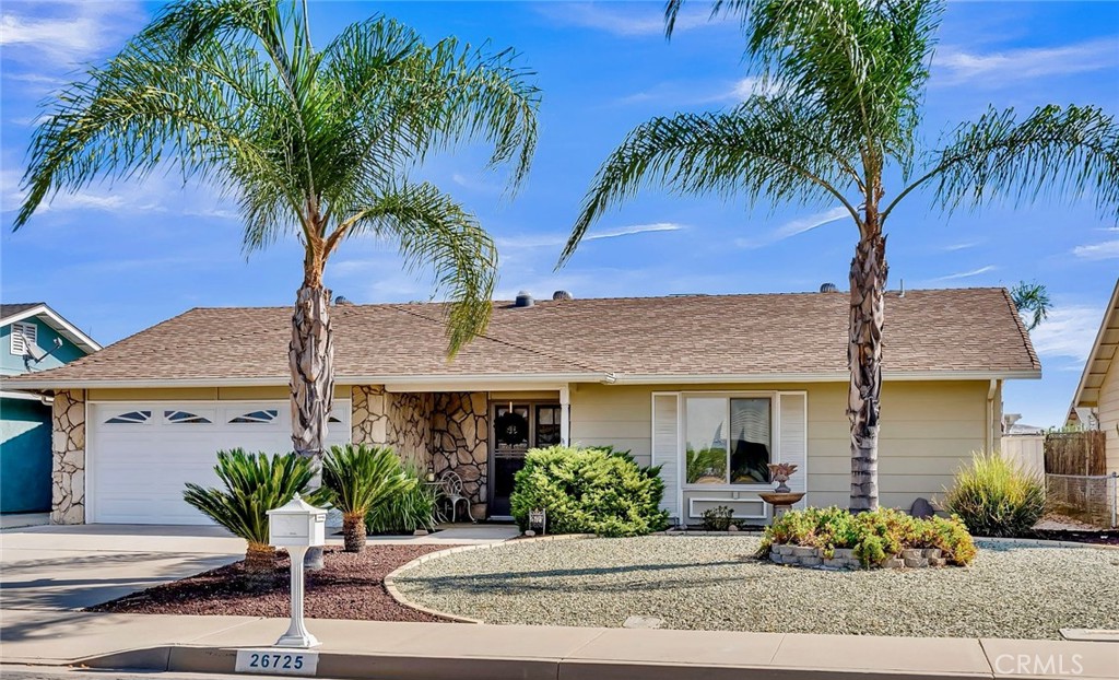 a front view of a house with garden and parking