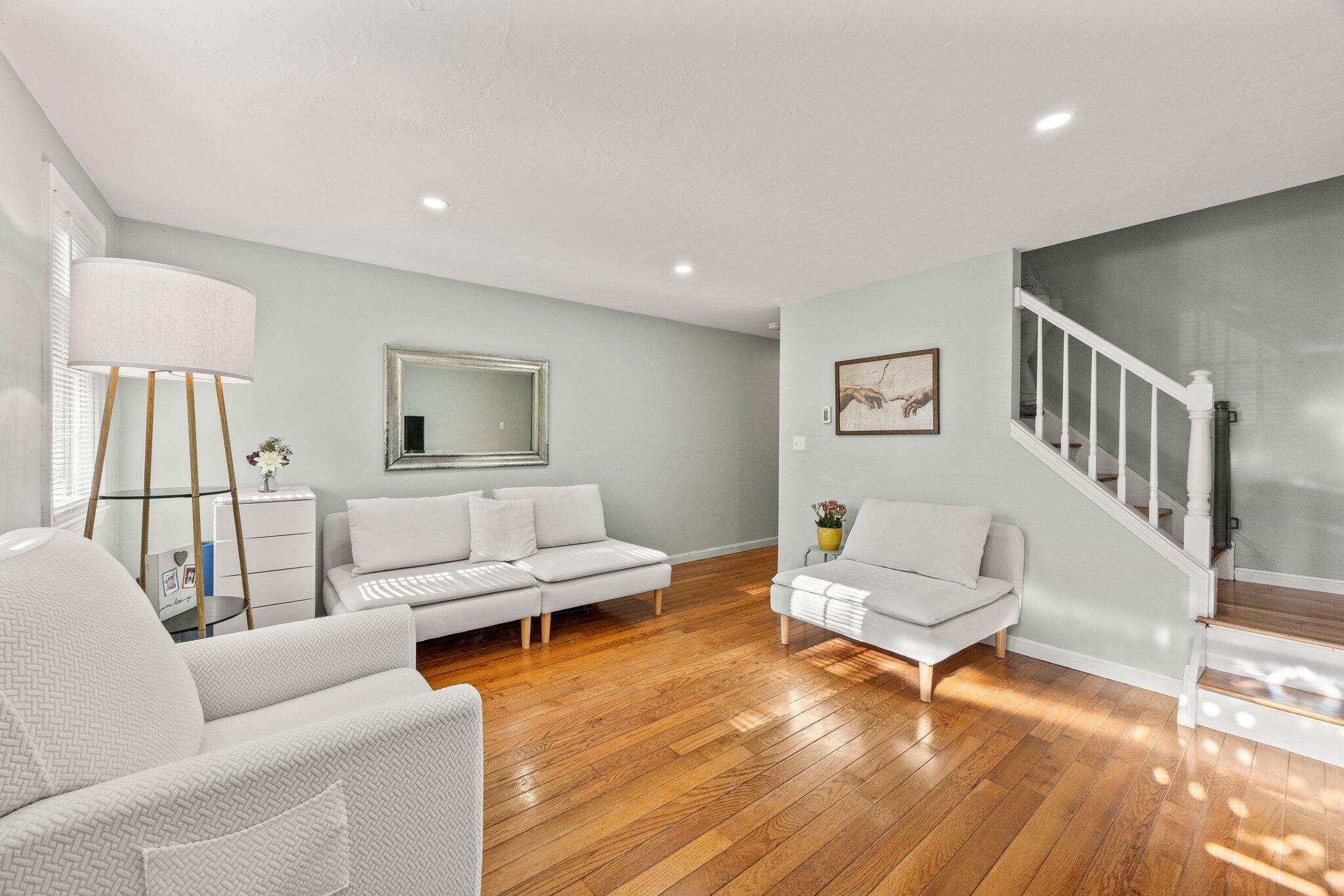 a living room with furniture and a wooden floor