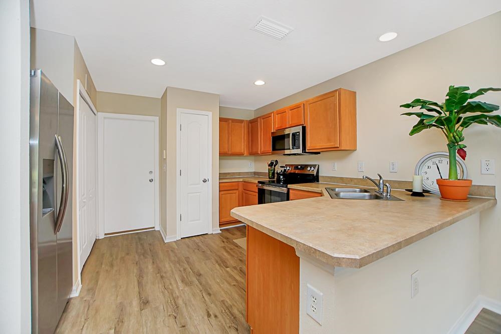 a kitchen with a sink a refrigerator and a stove top oven