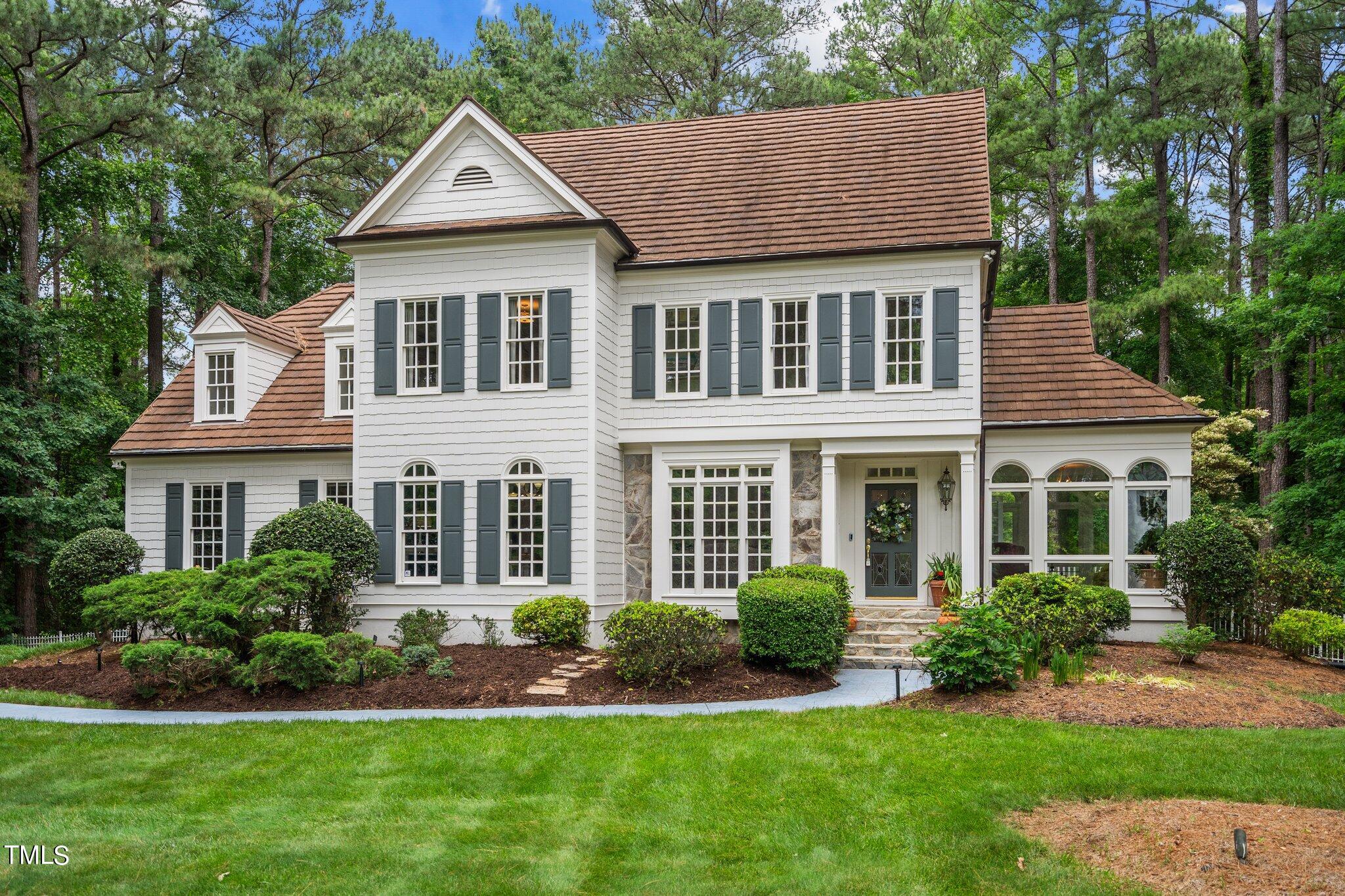 a front view of a house with a yard and potted plants