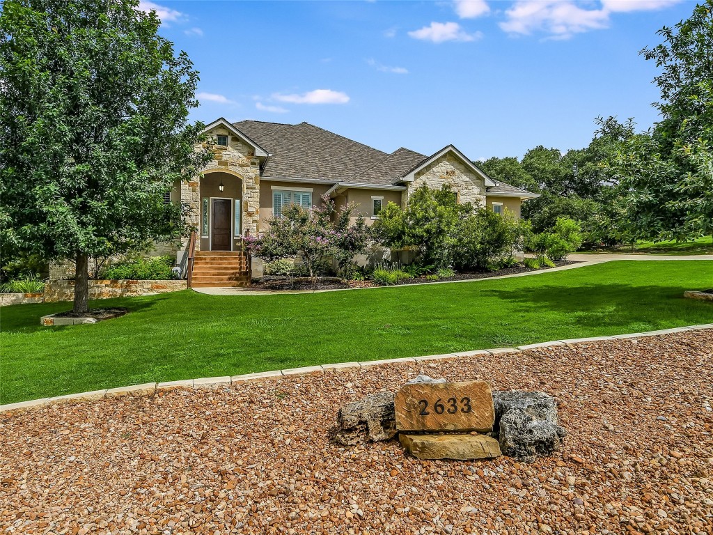 a view of a house with a yard and potted plants