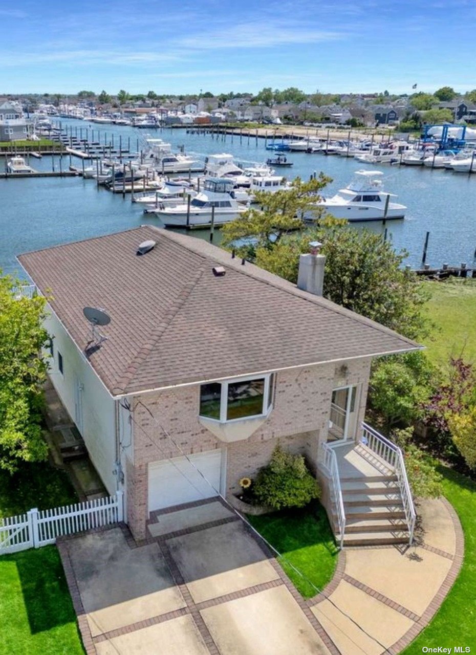 an aerial view of a house with a yard and lake view