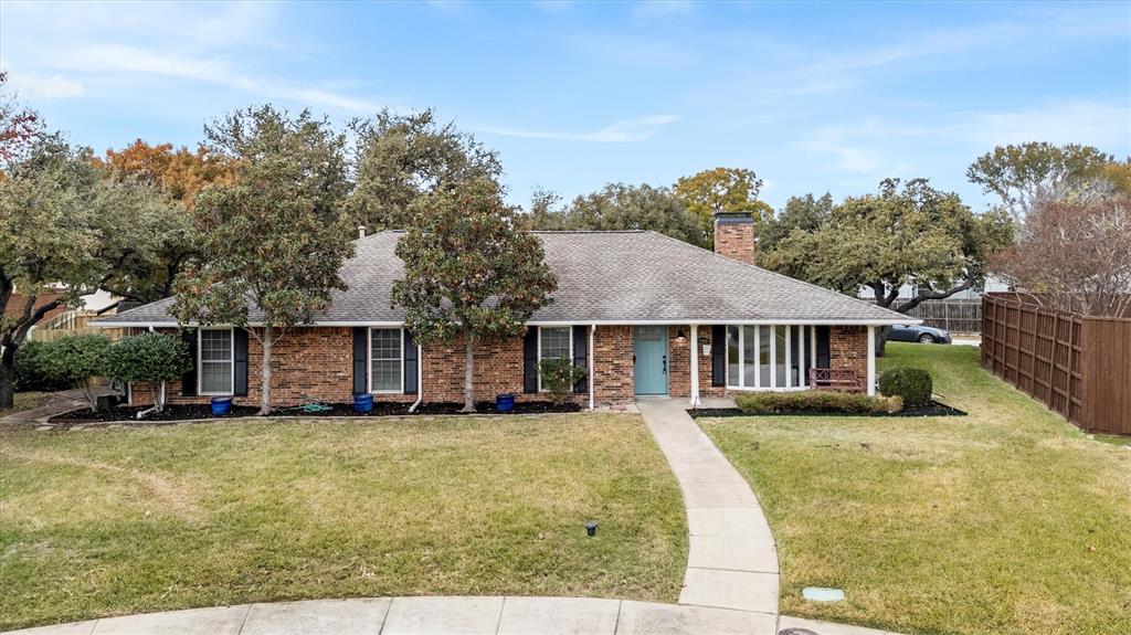 a front view of house with yard and trees in the background