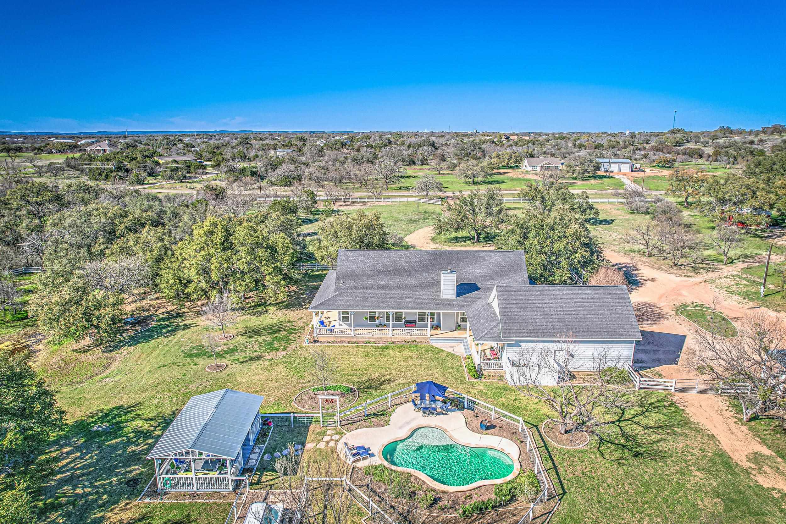 an aerial view of residential houses with outdoor space and swimming pool