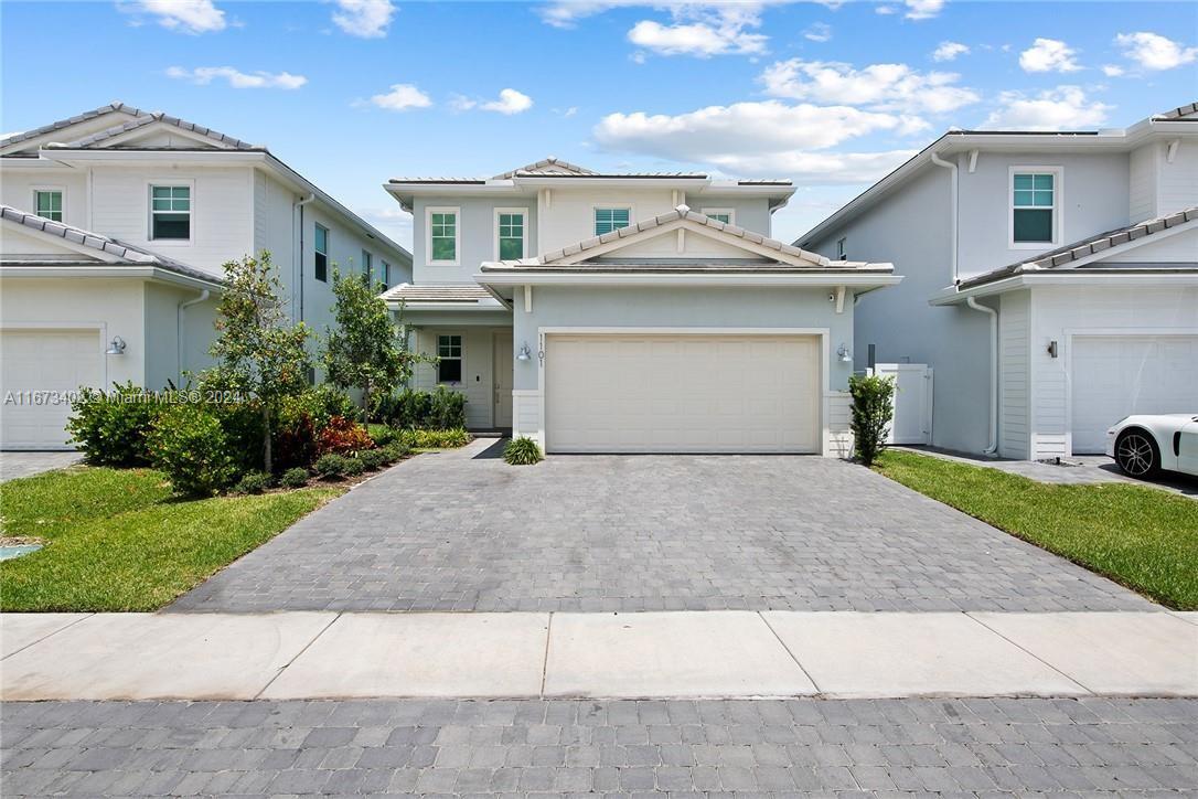 a front view of a house with a yard and a garage