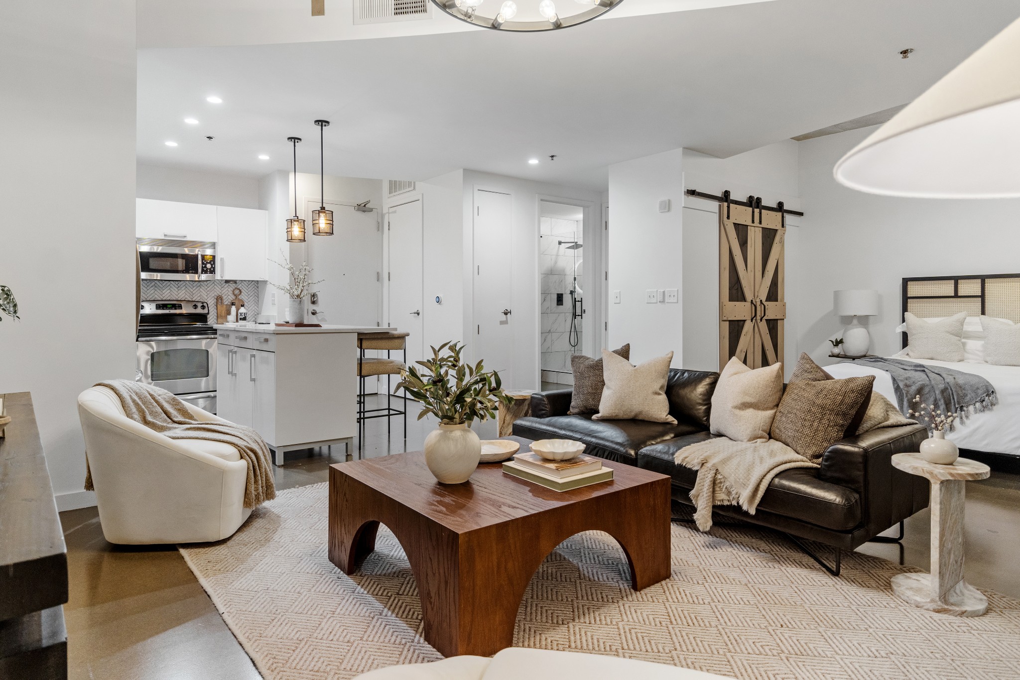 a living room with furniture a rug and kitchen view