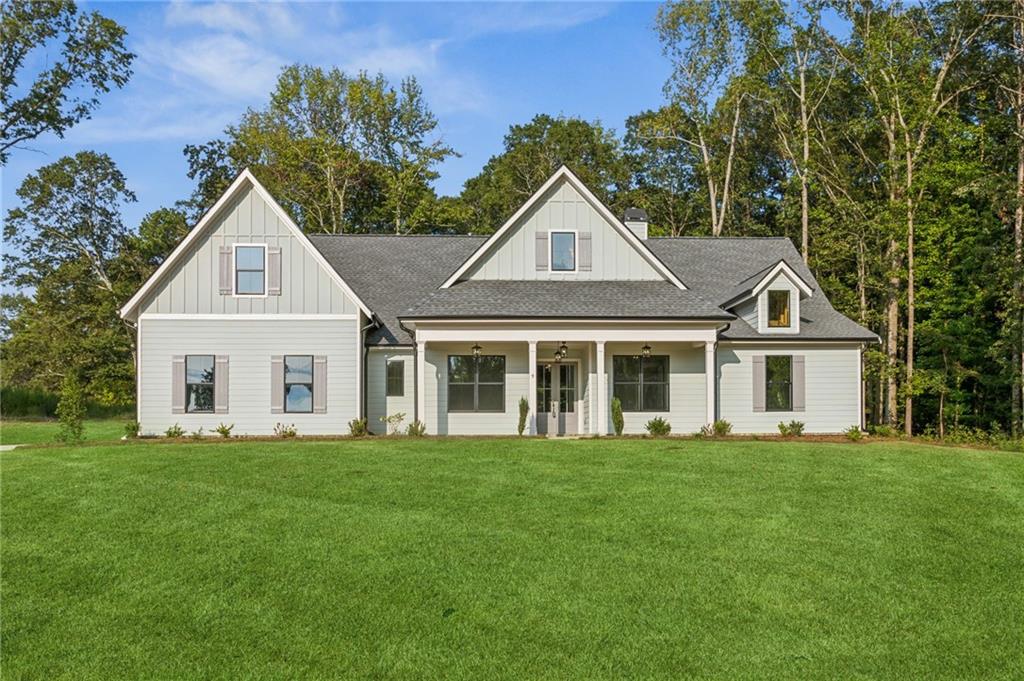 a front view of a house with a yard and trees