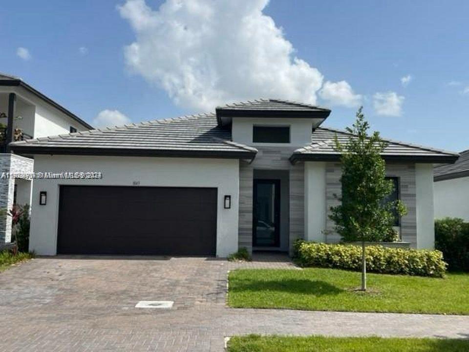 a front view of a house with a garden and garage