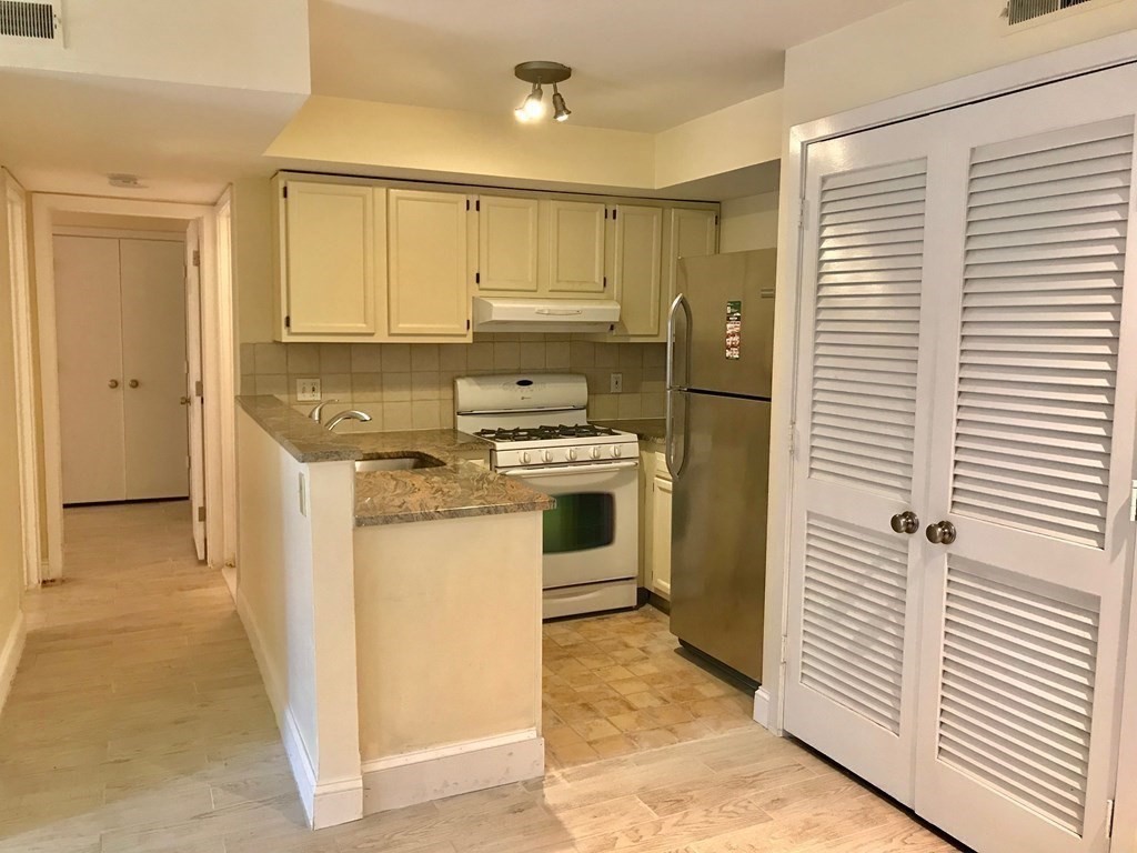 a kitchen with white cabinets and white appliances