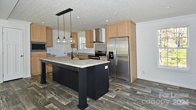 a kitchen with kitchen island granite countertop a sink stove and refrigerator