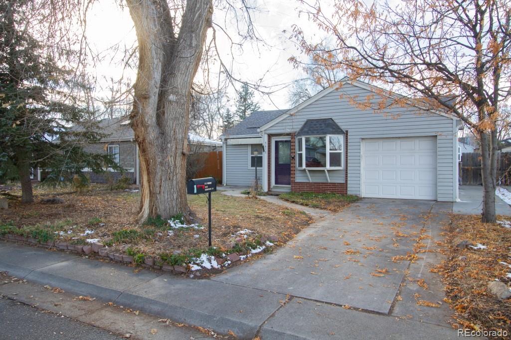 a front view of a house with yard garage and tree