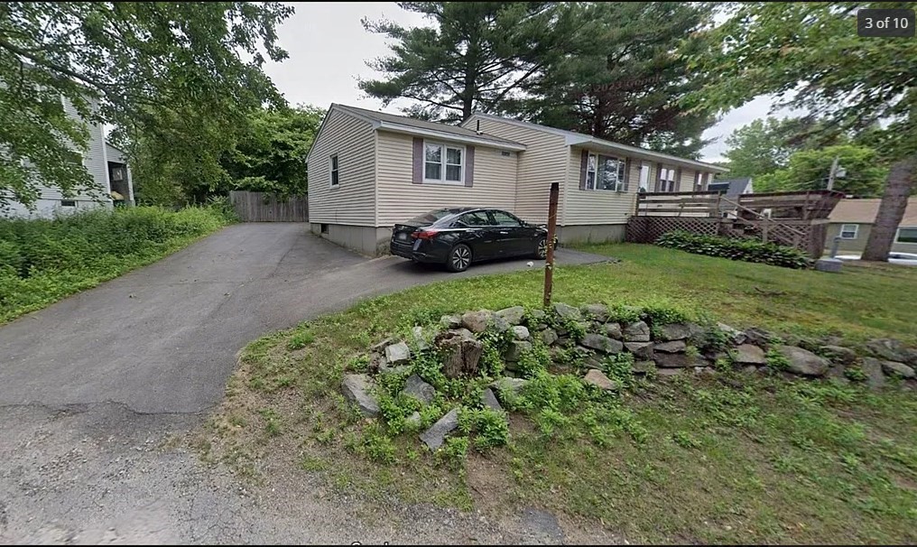 a view of a house with a backyard and trees