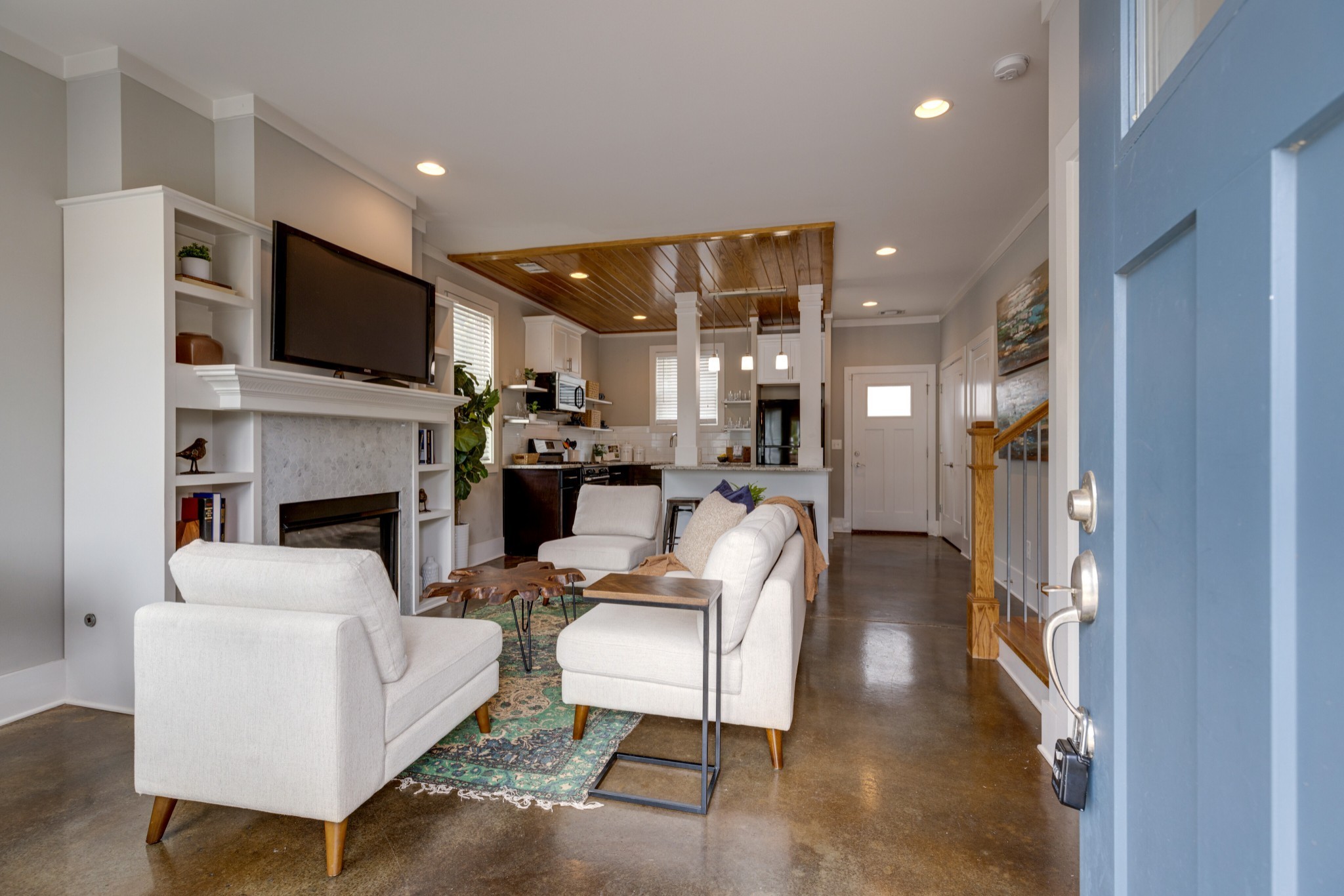 a living room with furniture a flat screen tv and a fireplace