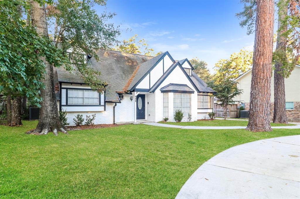 a front view of a house with a yard and trees