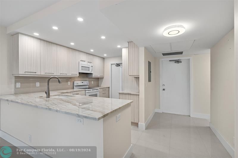 a kitchen with a sink a refrigerator and a stove top oven