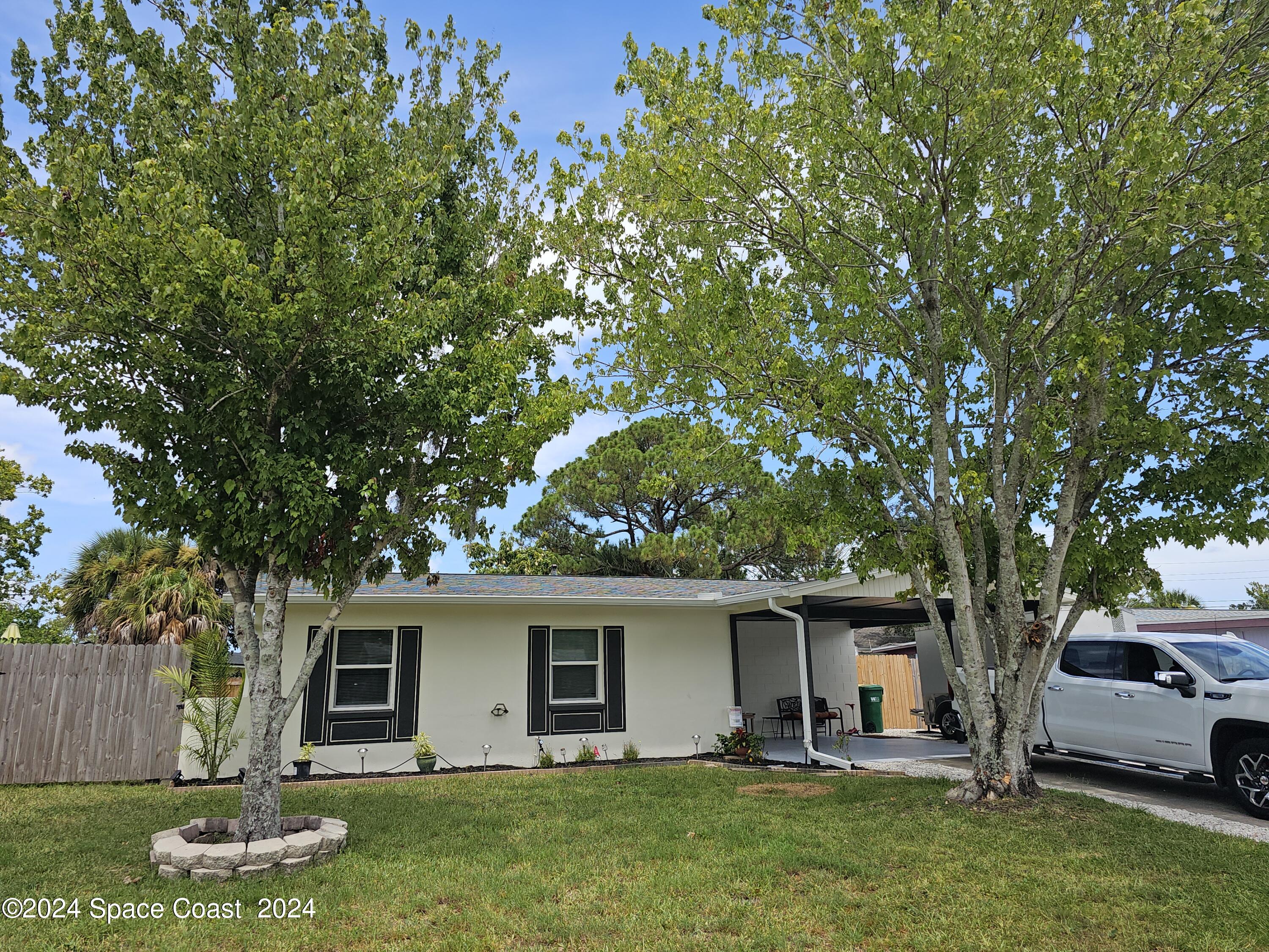 a front view of house with yard and trees