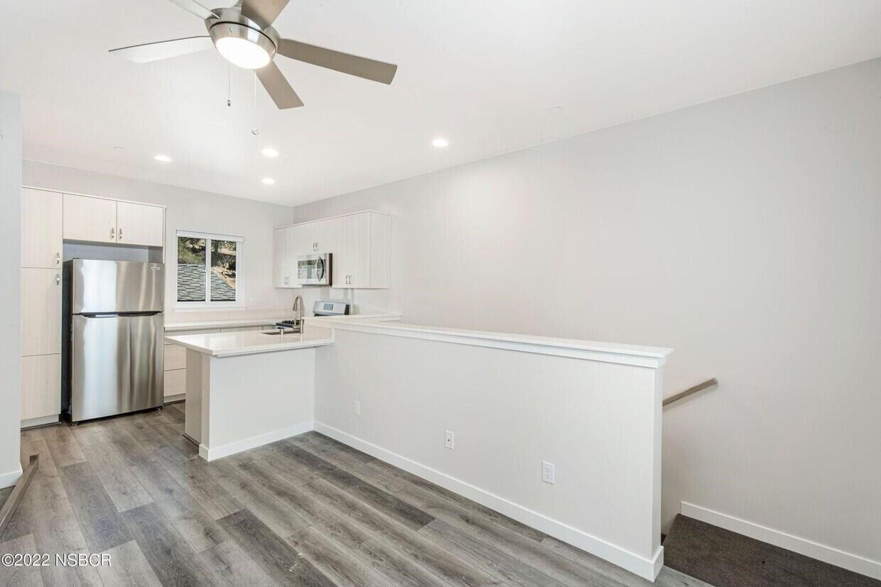 a kitchen with a refrigerator and white cabinets