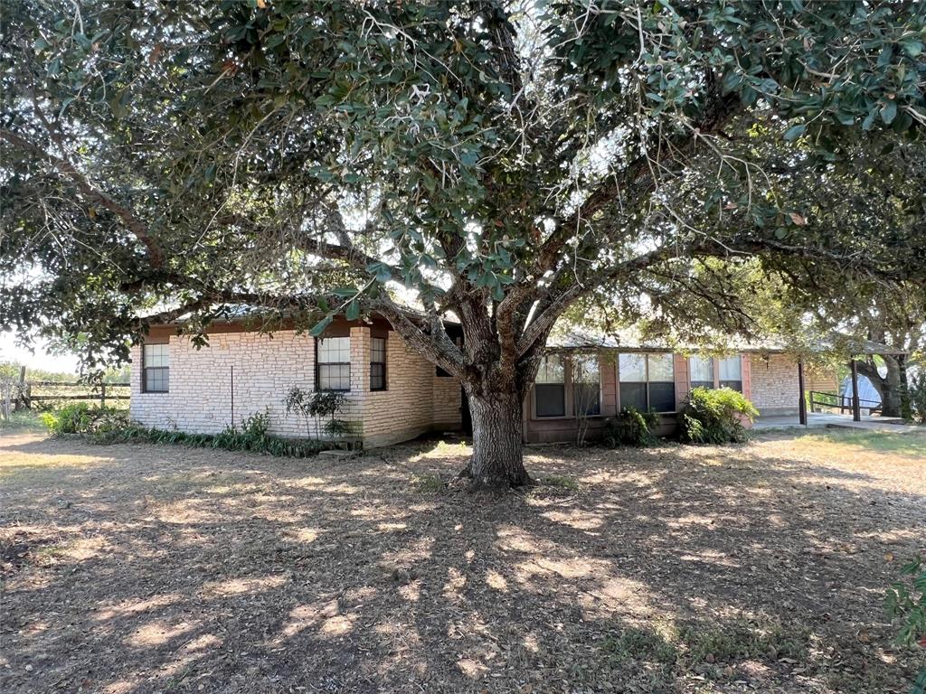 a view of a house with a tree in the background