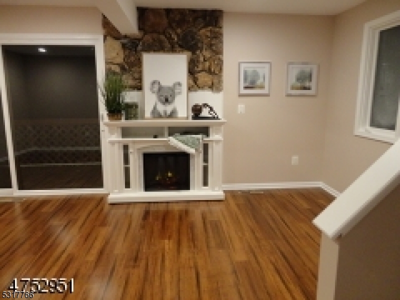 a view of a livingroom with wooden floor and a fireplace