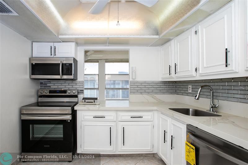 a kitchen with cabinets stainless steel appliances a sink and a counter top space