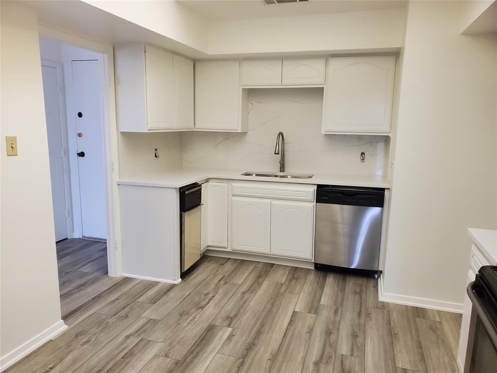 a kitchen with a sink and wooden floor