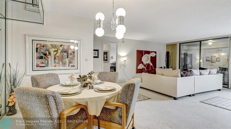 a view of a dining room with furniture a chandelier and wooden floor