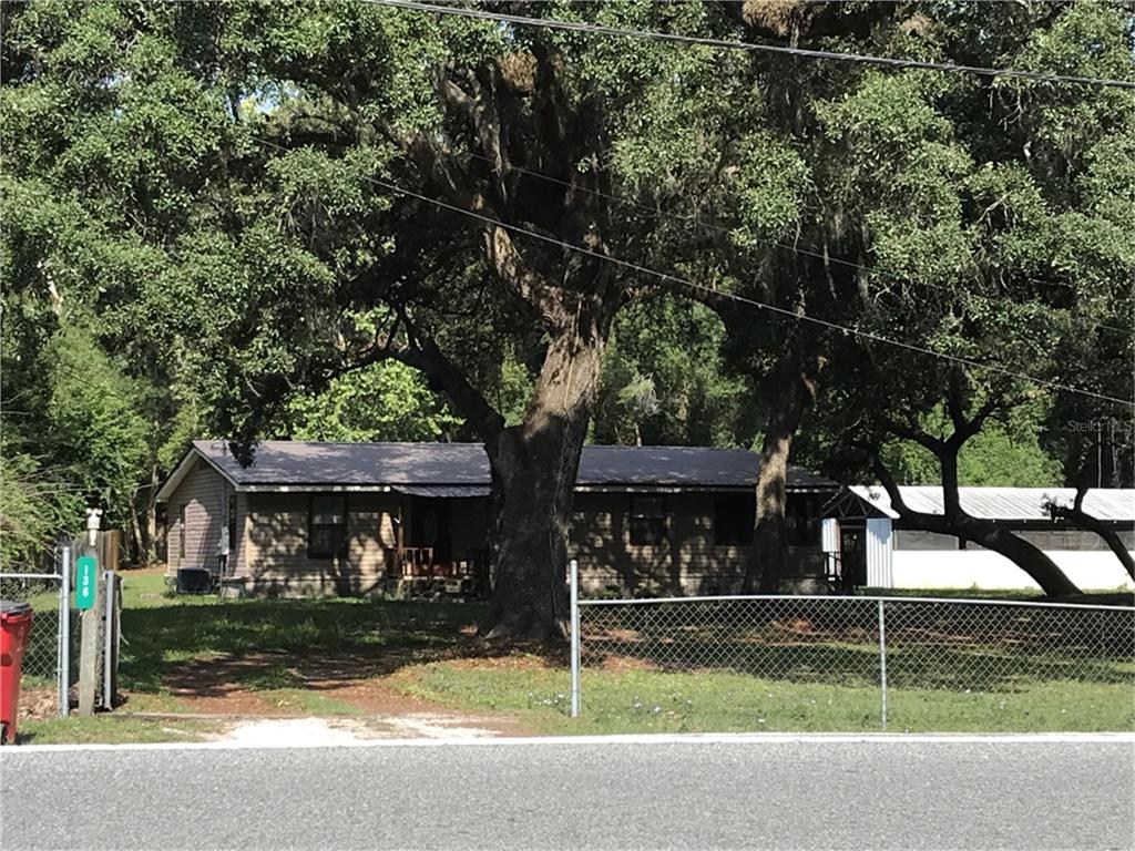 a view of a house with backyard and a tree