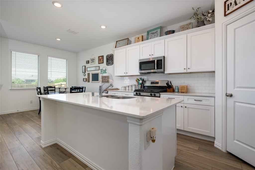 a kitchen with stainless steel appliances granite countertop a sink a stove a refrigerator and cabinets