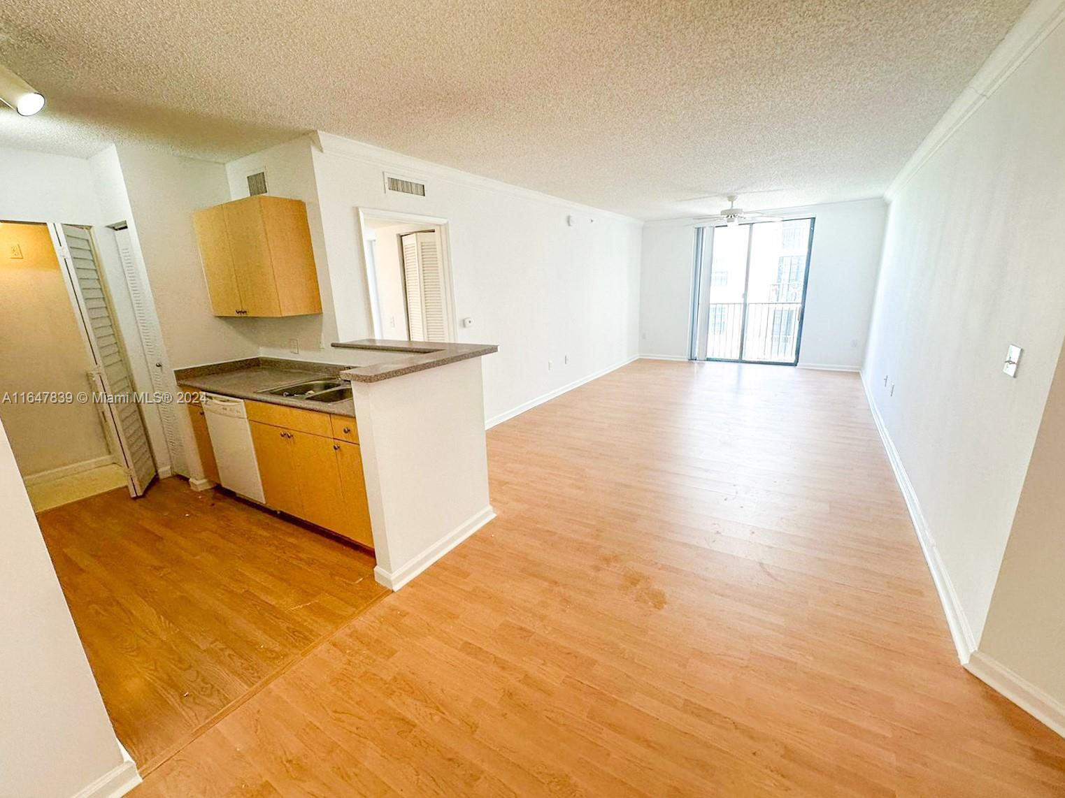 a view of a kitchen with stainless steel appliances granite countertop a stove a sink and a refrigerator