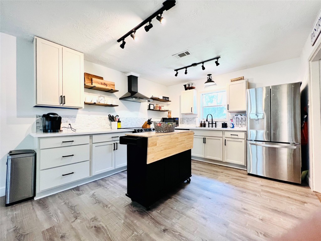 a kitchen with stainless steel appliances kitchen island hardwood floor sink and stove