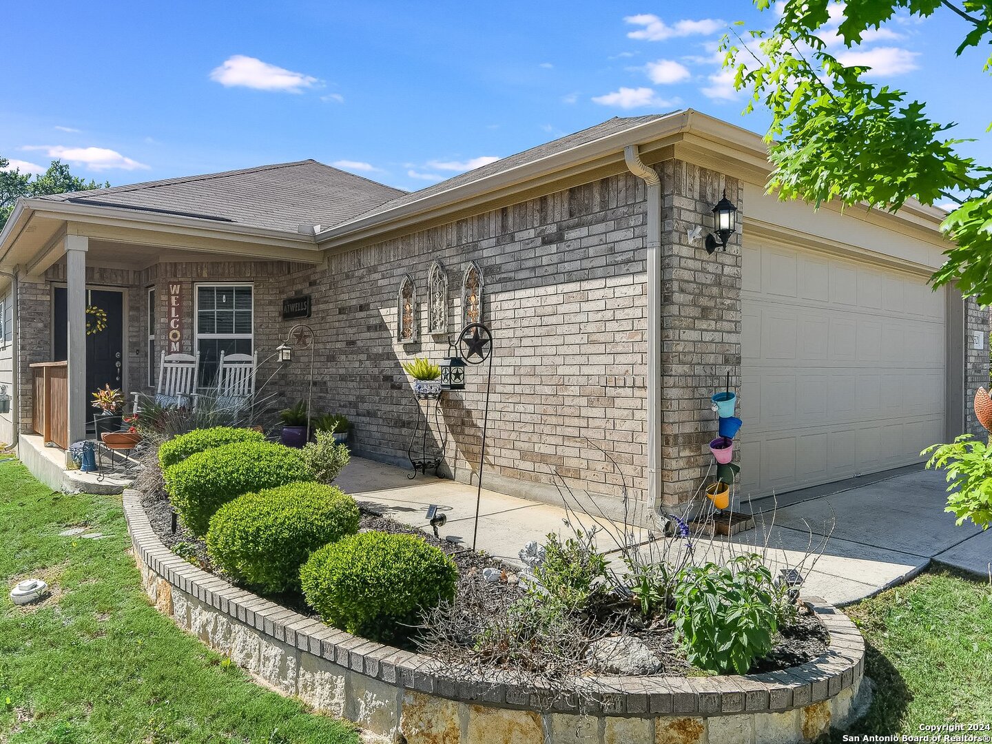 a front view of a house with a yard and potted plants